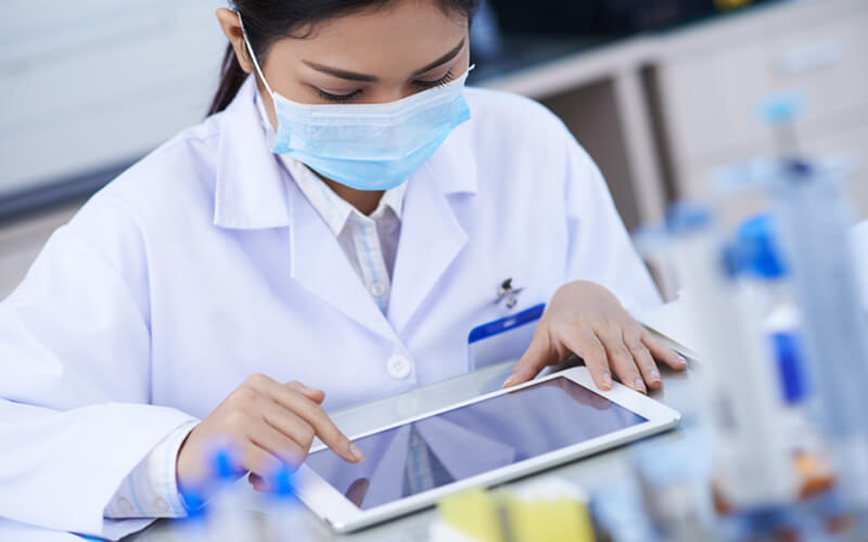 Une scientifique travaillant dans le laboratoire avec une tablette.