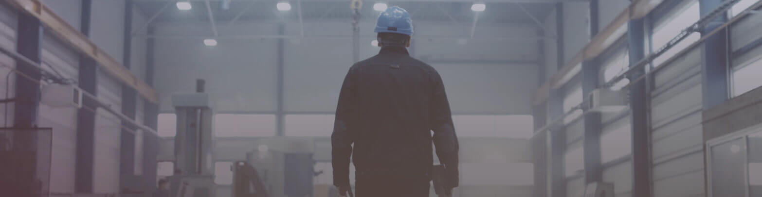 Factory worker walking down manufacturing plant