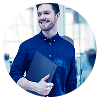 Man in beard smiling holding laptop