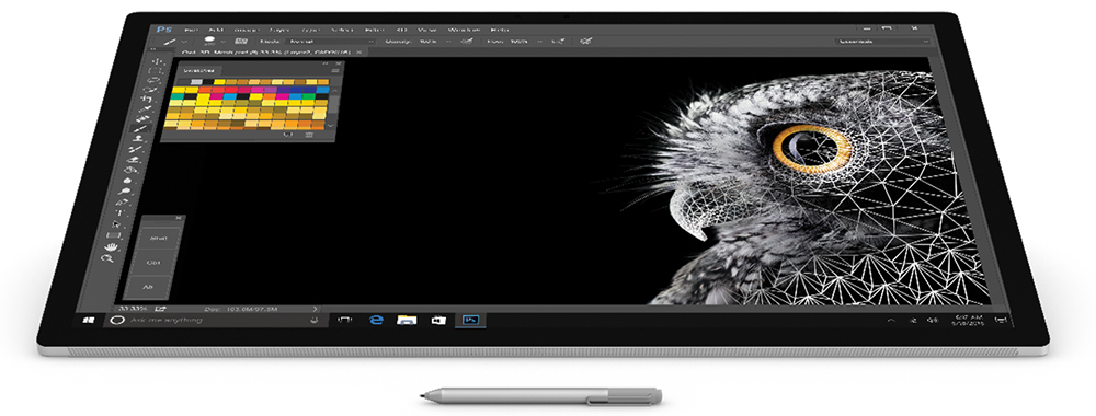 Microsoft Surface Studio desktop computer displayed with monitor lowered, Surface pen and Adobe Photoshop on screen