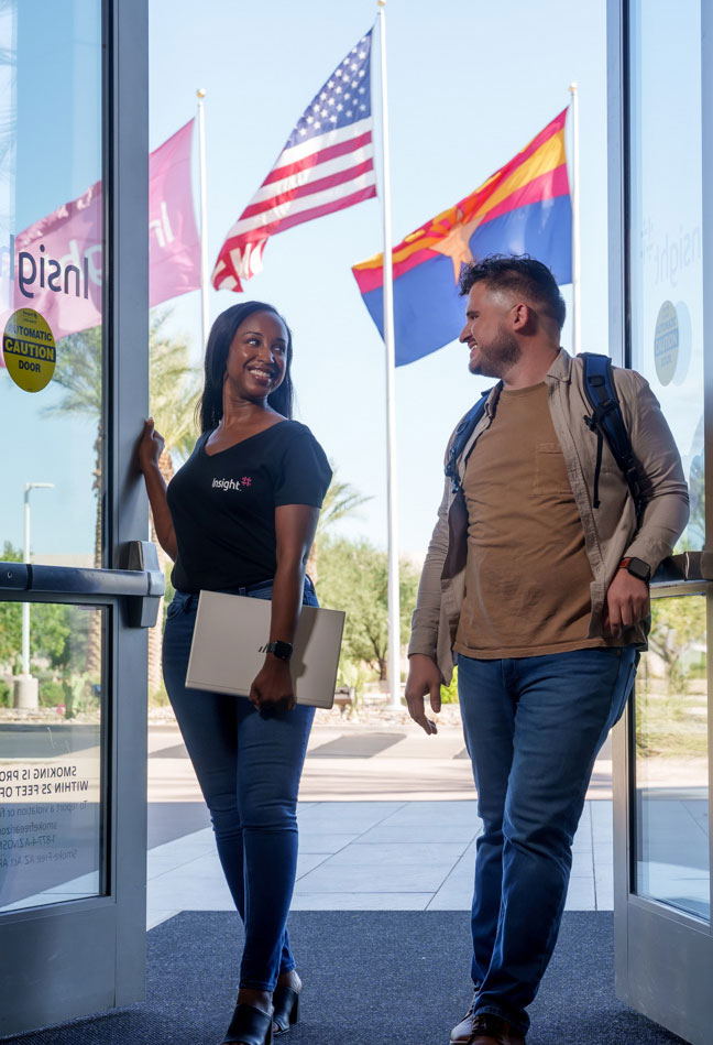 Two smiling Insight employees walking into Insight headquarters in Chandler, Arizona.