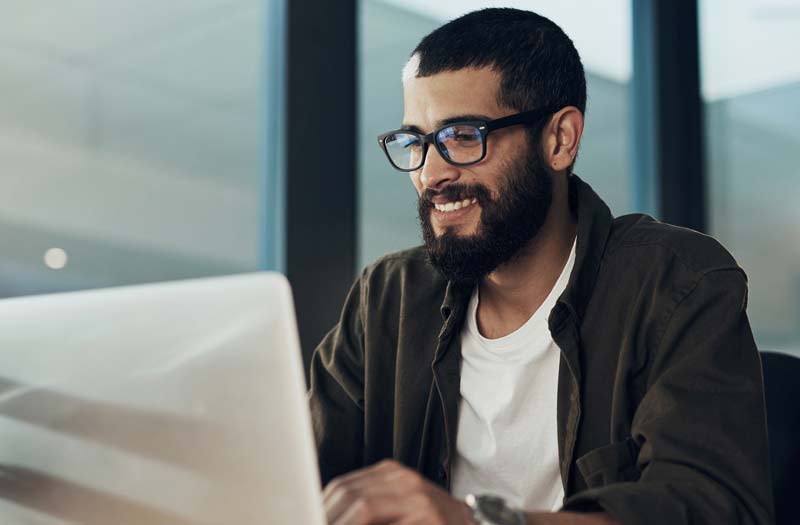 Man with glasses using his laptop