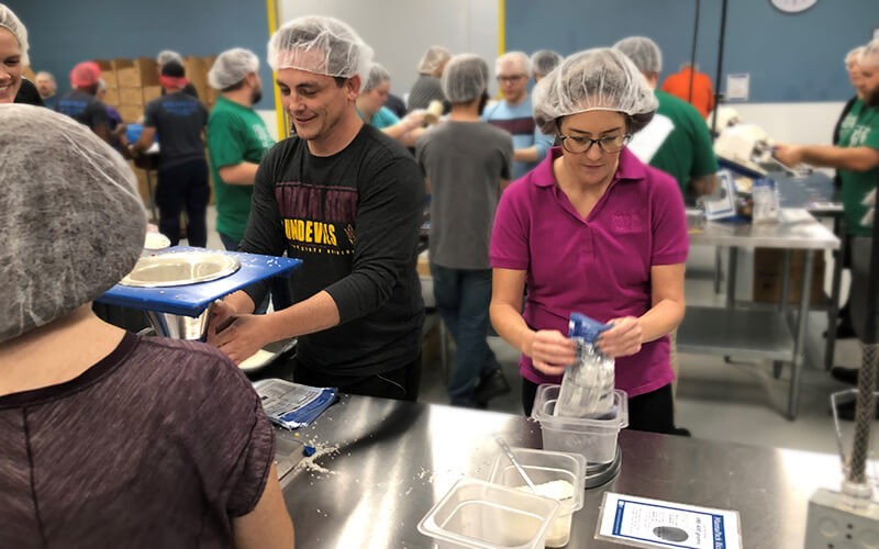 Insight teammates participate in packing food for Feed the Starving Children non-profit