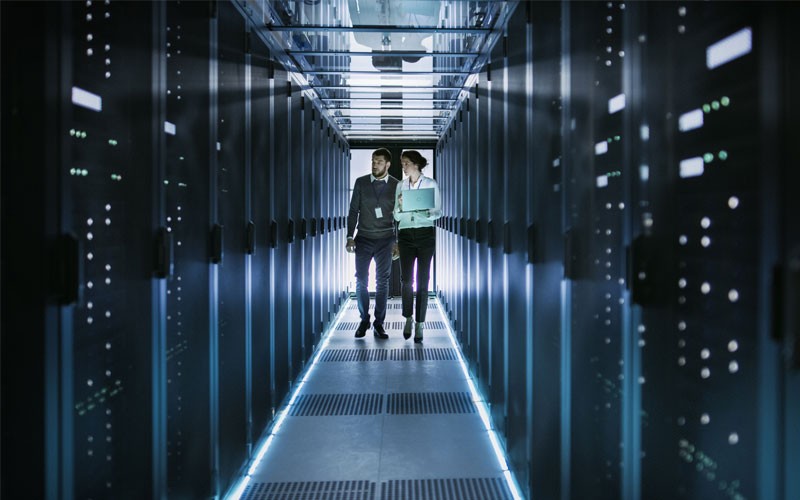 Two professionals looking on data center