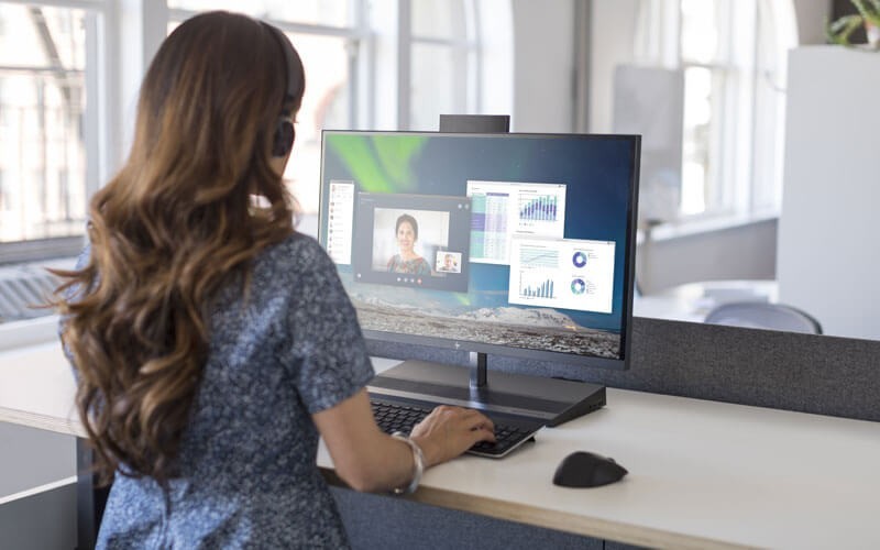 Woman on call using HP all-in-one PC at desk