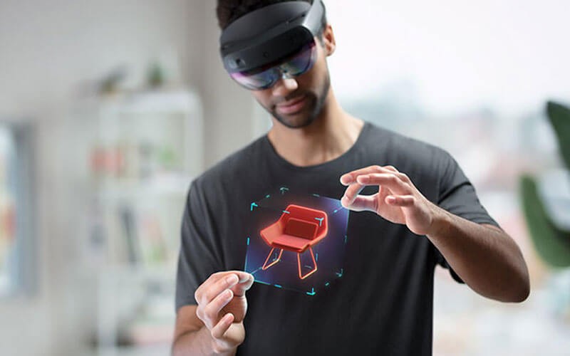 Creative designer using HoloLens 2 to create a new chair design concept.
