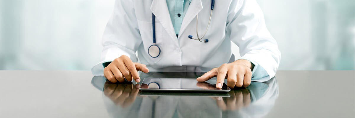 doctor using tablet sitting at a table