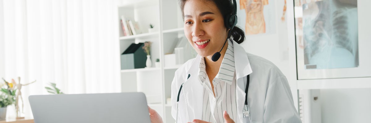 Doctor with headset on telehealth call with patient