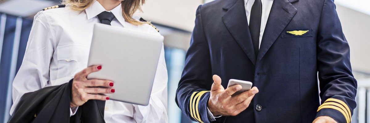 Close up of airline pilots looking at tablet device