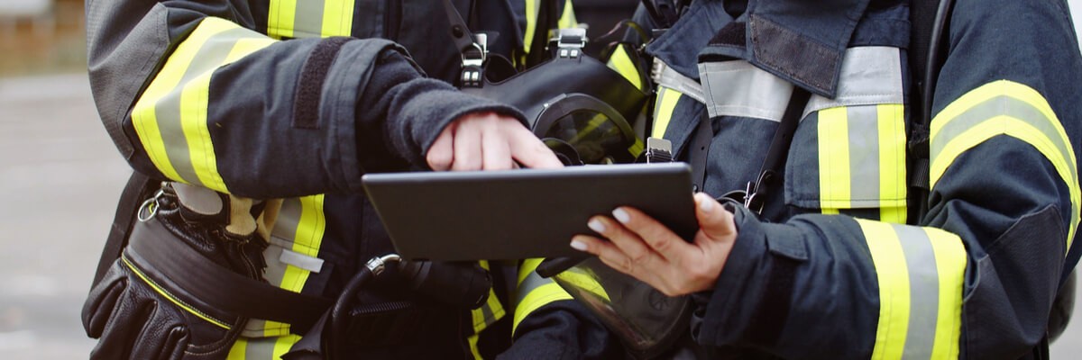 Firefighters holding tech device
