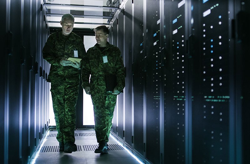Two department of defense employees walk through data center