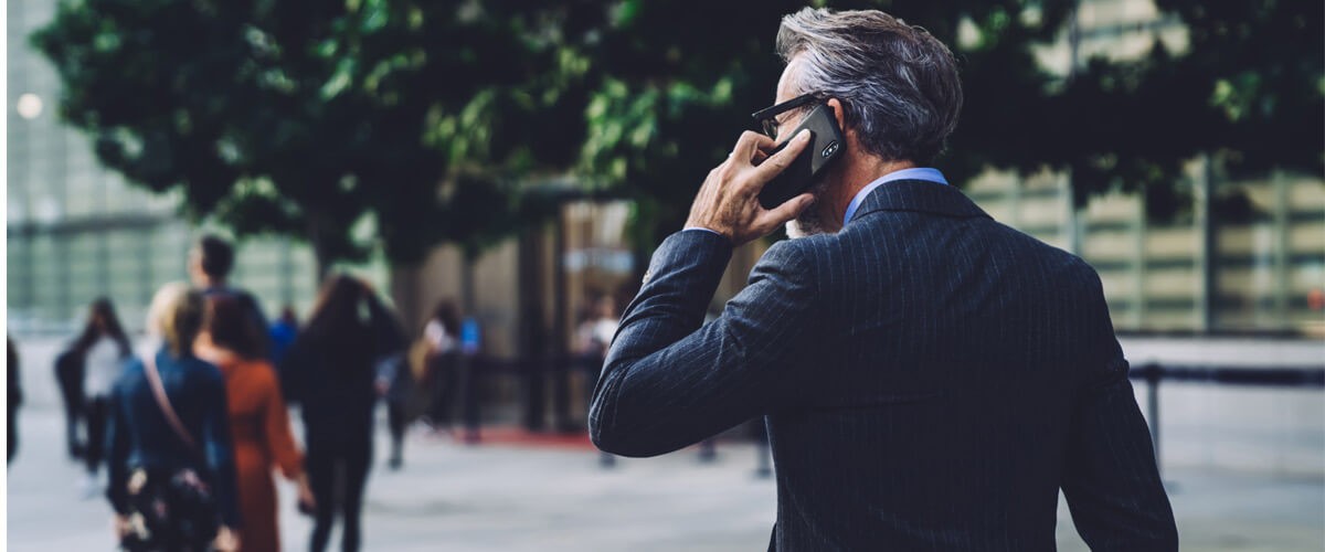 Business man speaking on phone outside