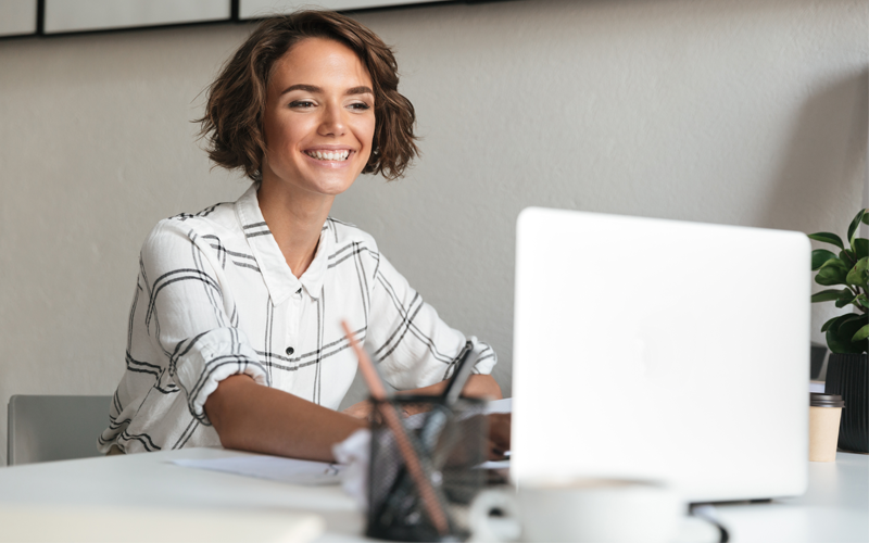 Woman smiling while working on computer