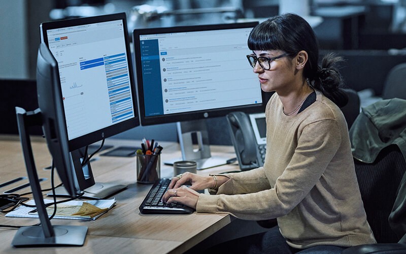 Woman with glasses working using a HP computer at the office