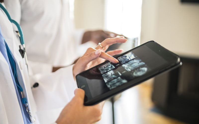 Doctor looking at medical X-ray on tablet device