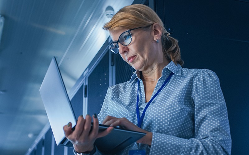 Woman using laptop on data center