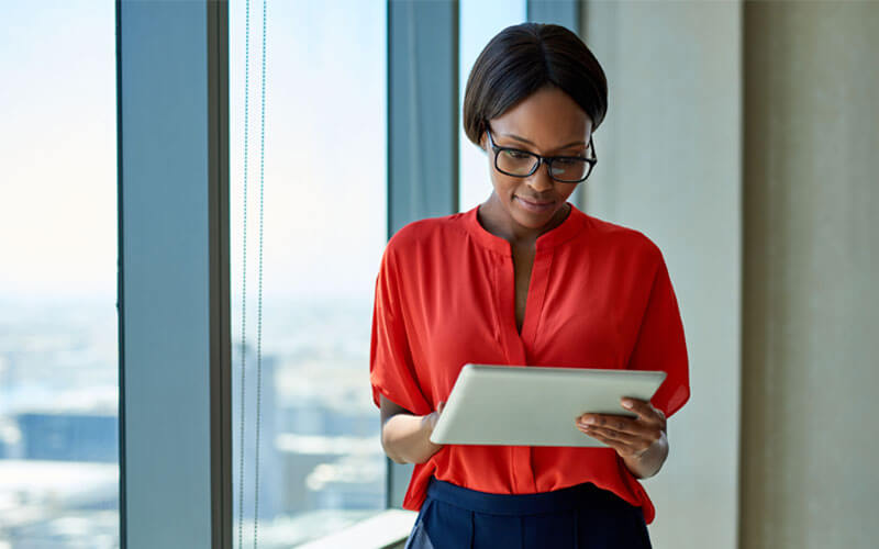 Business woman reading Cisco MSLA whitepaper off of tablet computer