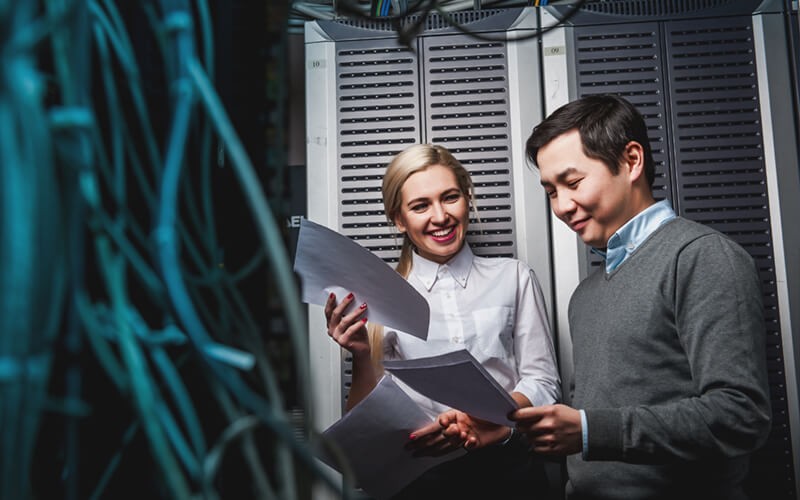 Business employees in server room