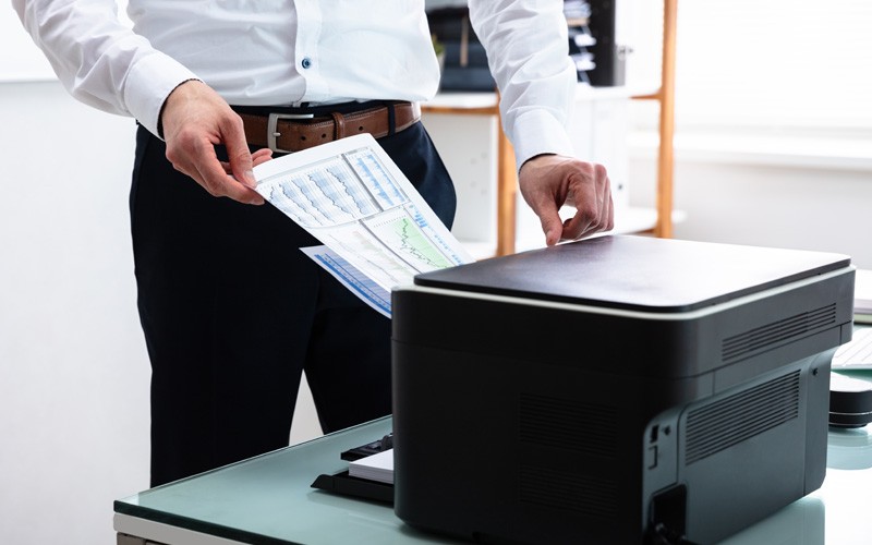 Businessman printing off graph from printer