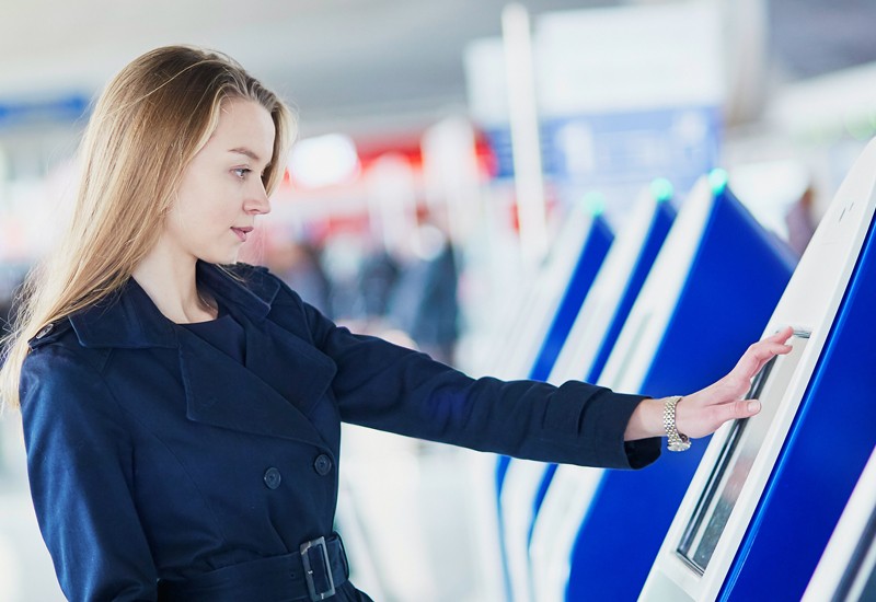 Business woman using touch screen on kiosk device